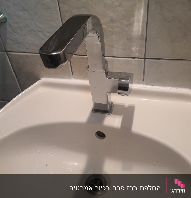 ברז כרום מעל כיור לבן עם ניקוז